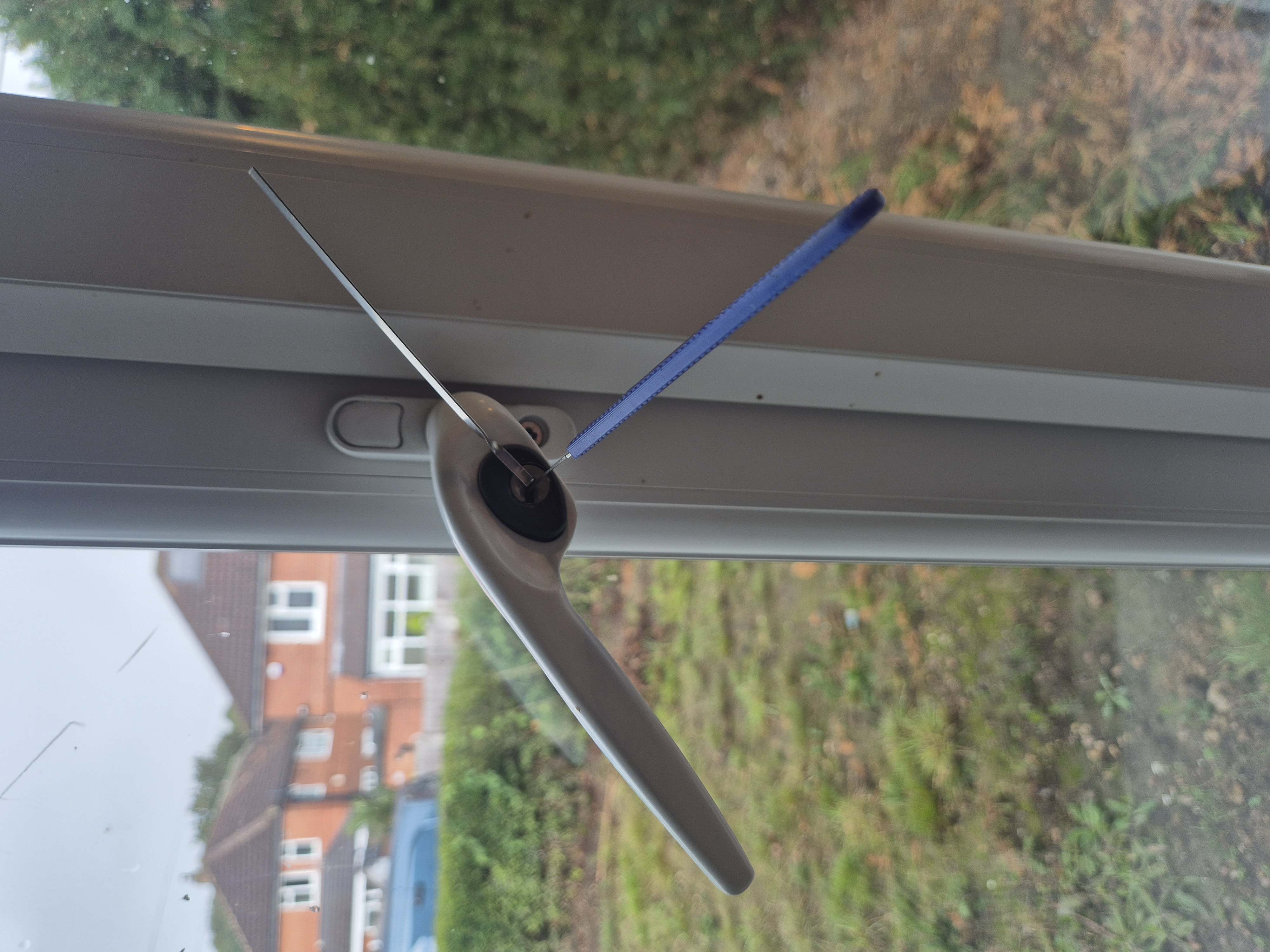 White upvc window handle picked open with tension tool and blue hook pick